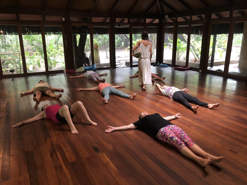 Mujeres acostadas en relajación sobre el piso de una sala de madera en la selva