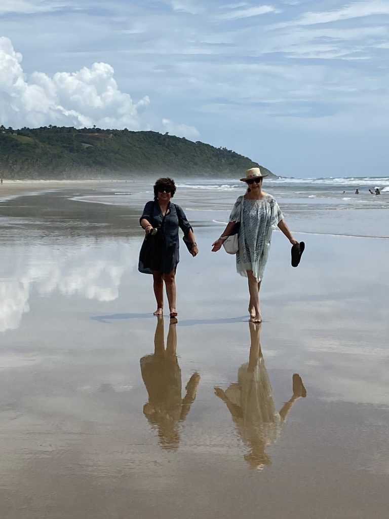 Dos mujeres caminando por la orilla de una playa en Serra Grande, Brasil