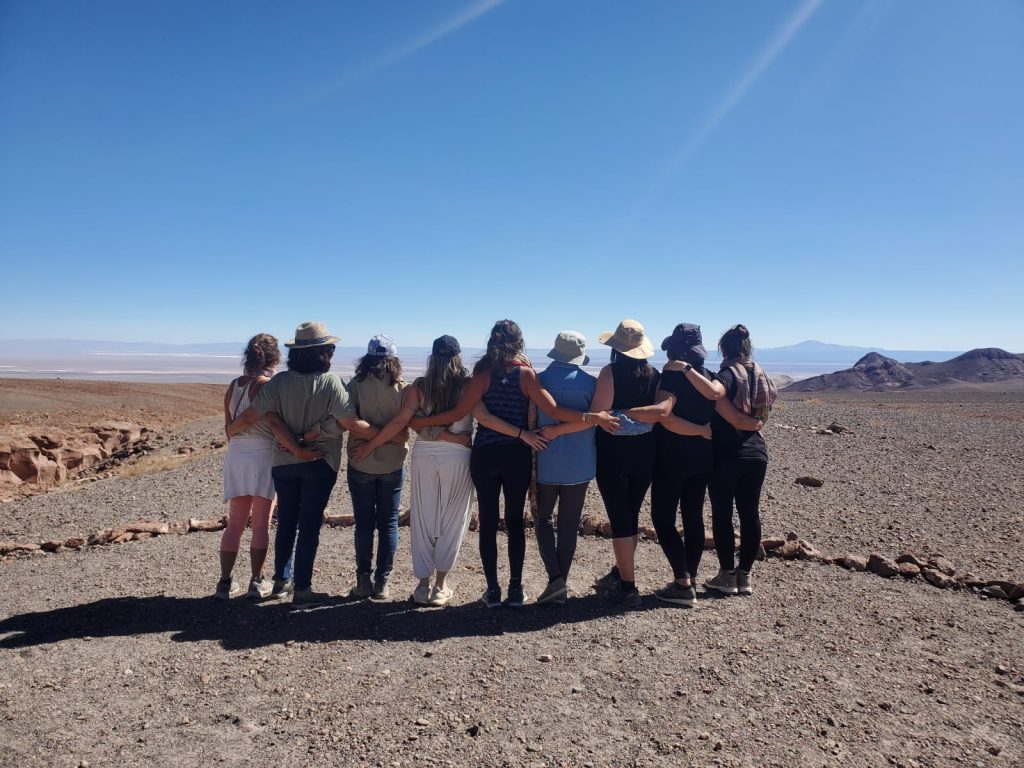 Mujeres abrazadas mirando el desierto de Atacama al final de un retiro espiritual