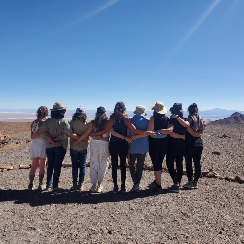 Mujeres abrazadas mirando el desierto de Atacama al final de un retiro espiritual
