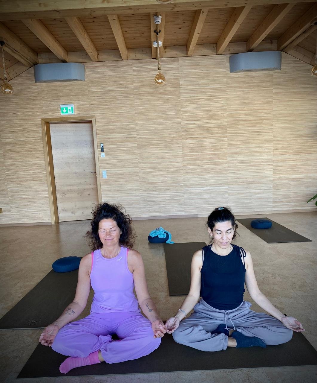Lore de Nordenflycht meditando junto a una alumna en la sala de yoga de un hotel en Alemania