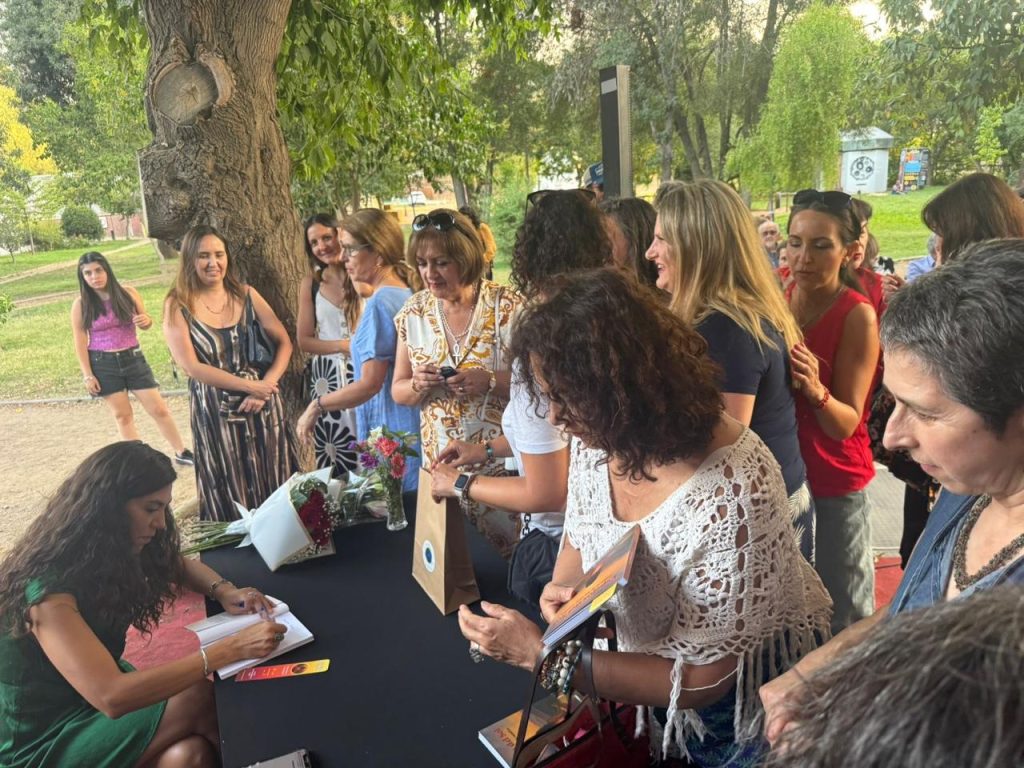 Lanzamiento del libro en Los Andes: Lore firmando ejemplares frente a una fila de asistentes