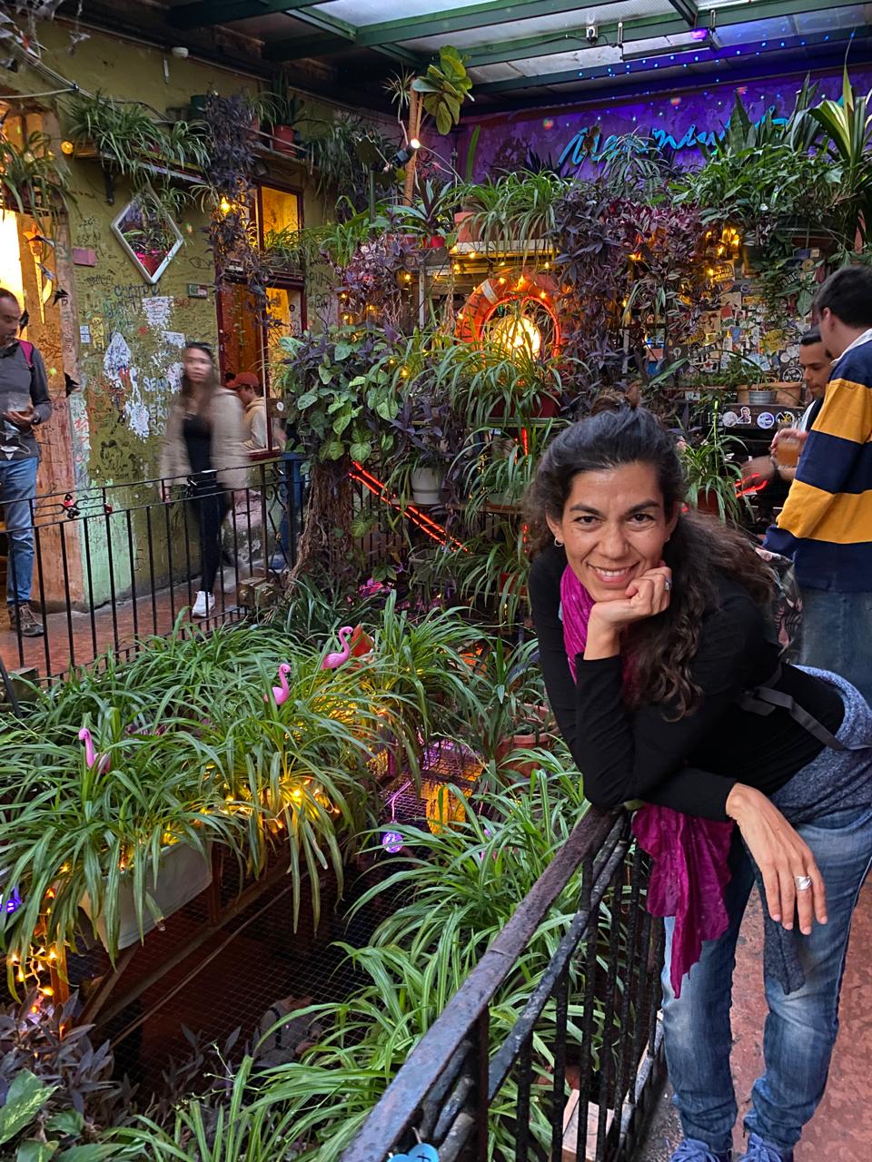 Lore de Nordenflycht sonriendo, apoyada en una baranda en un patio lleno de plantas de Budapest