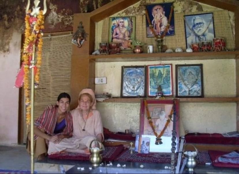 Lore de Nordenflycht en un ashram de India, frente a un altar con imágenes de maestros